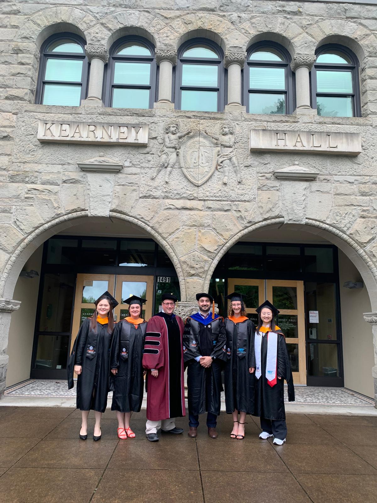 Graduates and faculty outside Kearney Hall